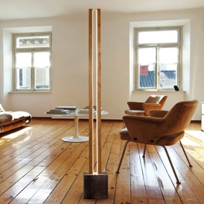 Modern Lubois floor LED light lamp by Cinier, featuring two chestnut wood posts, a raw concrete stone base with hand patina, and adjustable brightness