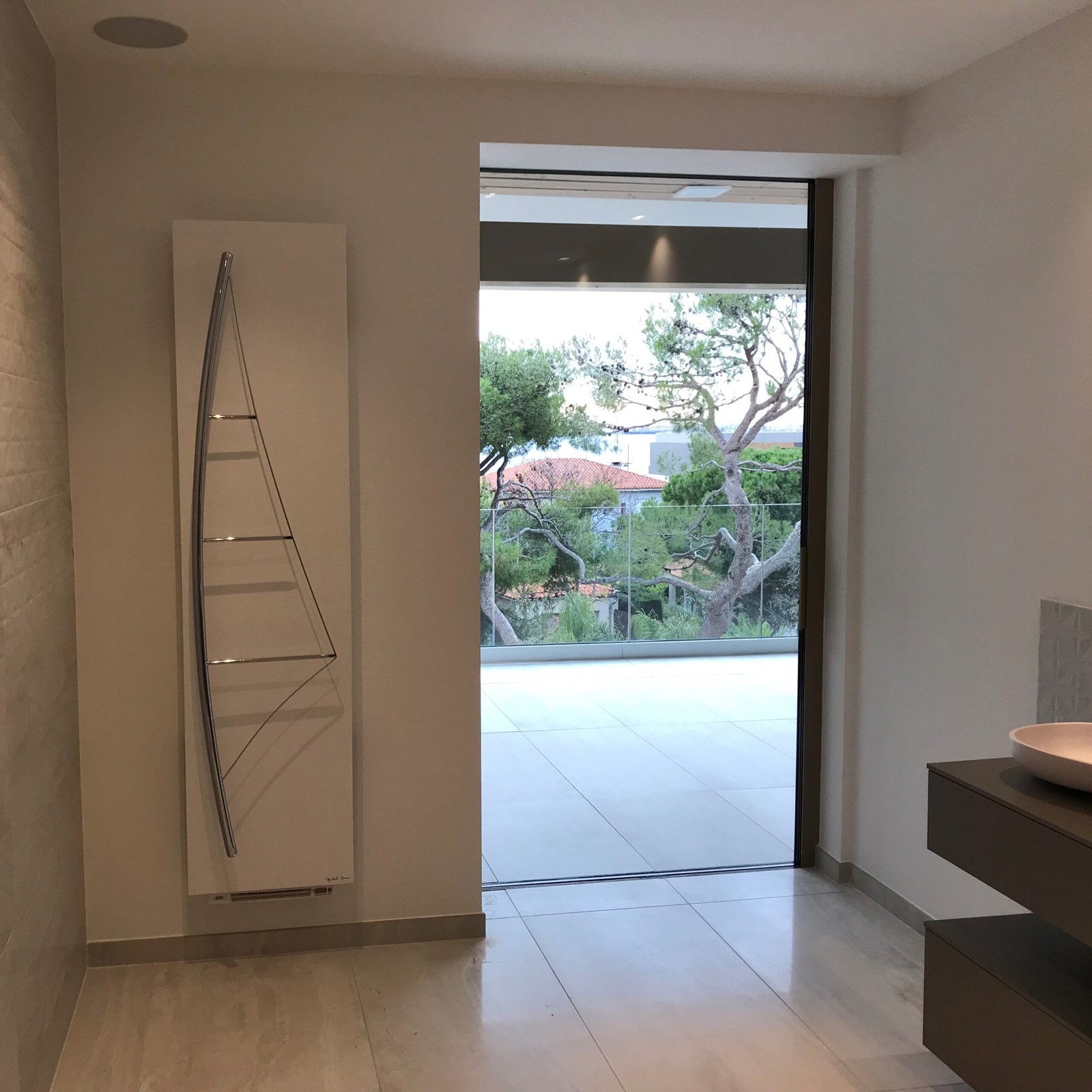 Luxury Voile bath towel warmer radiator, designed with a yachting-inspired chrome sail and practical hooks