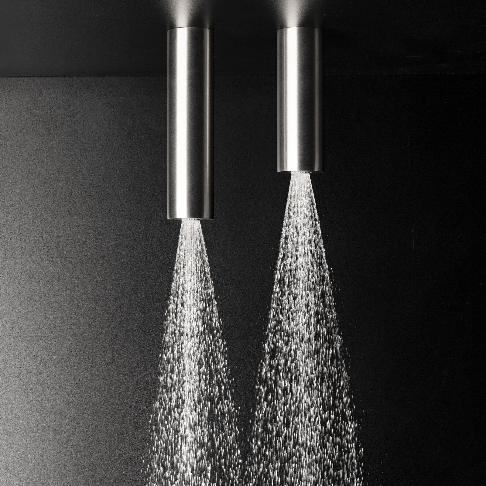 Three elegant cylindrical rainfall shower heads in varying heights, crafted from high-grade stainless steel