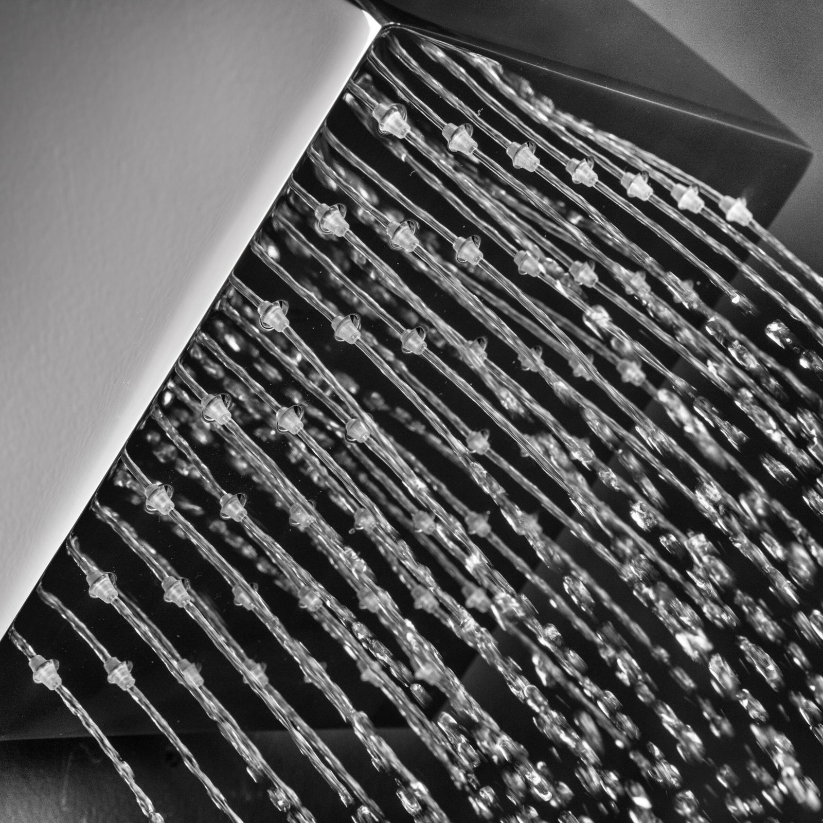 Modern wall-mounted square shower head with 48 rubber nozzles, offering consistent water flow and long-lasting shine