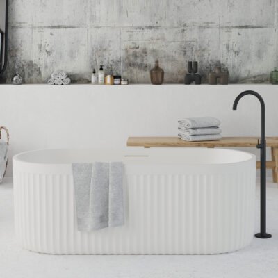 Modern white freestanding bathtub with ribbed exterior texture, placed in a minimalist bathroom interior