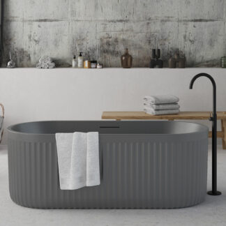 Freestanding cement grey bathtub with ribbed stone-texture exterior and modern minimalist design.