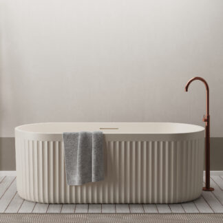 Cream-colored freestanding bathtub with ribbed rock-texture exterior, set in a minimalist modern bathroom.
