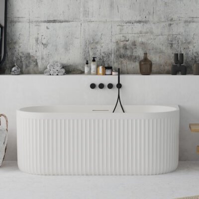 Back-to-wall white freestanding bathtub with ribbed stone-textured exterior from Ideavit’s ARCHTEC collection.
