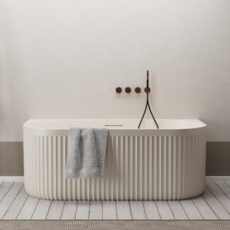 Cream-colored back-to-wall bathtub with ribbed Rock Texture finish from the Ideavit ARCHTEC collection.