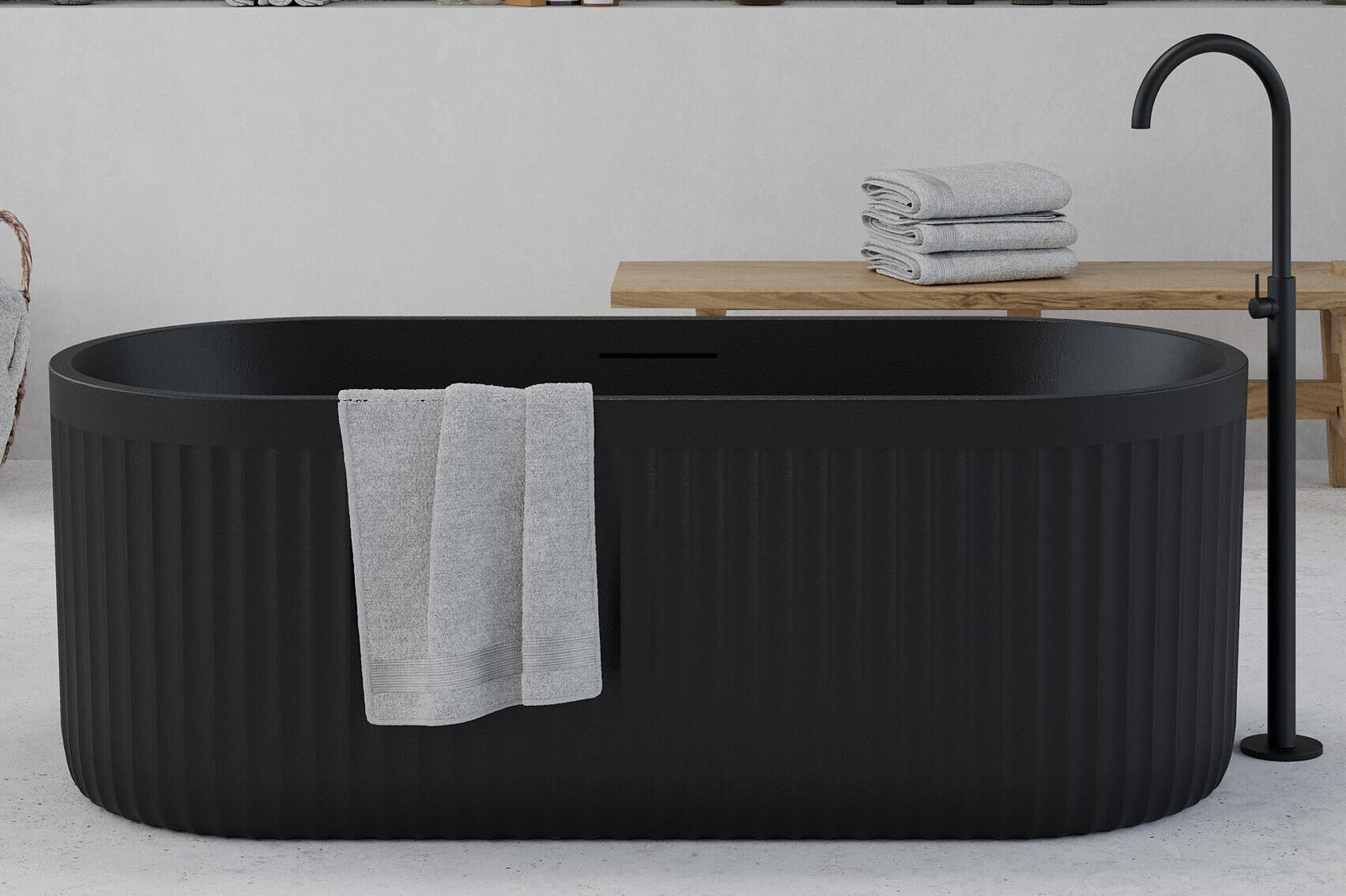 Freestanding black bathtub with textured ribbed exterior from Ideavit's ARCHTEC Collection, set in a minimalist bathroom.