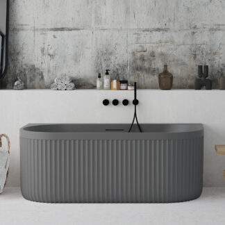 Back-to-wall grey freestanding bathtub with ribbed stone-textured exterior from Ideavit’s ARCHTEC collection.