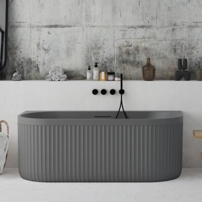 Back-to-wall grey freestanding bathtub with ribbed stone-textured exterior from Ideavit’s ARCHTEC collection.