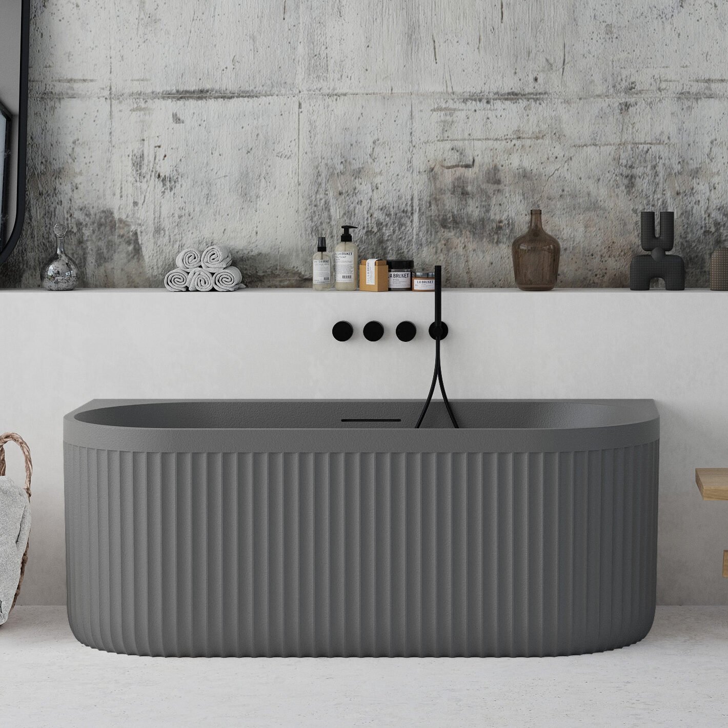 Back-to-wall grey freestanding bathtub with ribbed stone-textured exterior from Ideavit’s ARCHTEC collection.