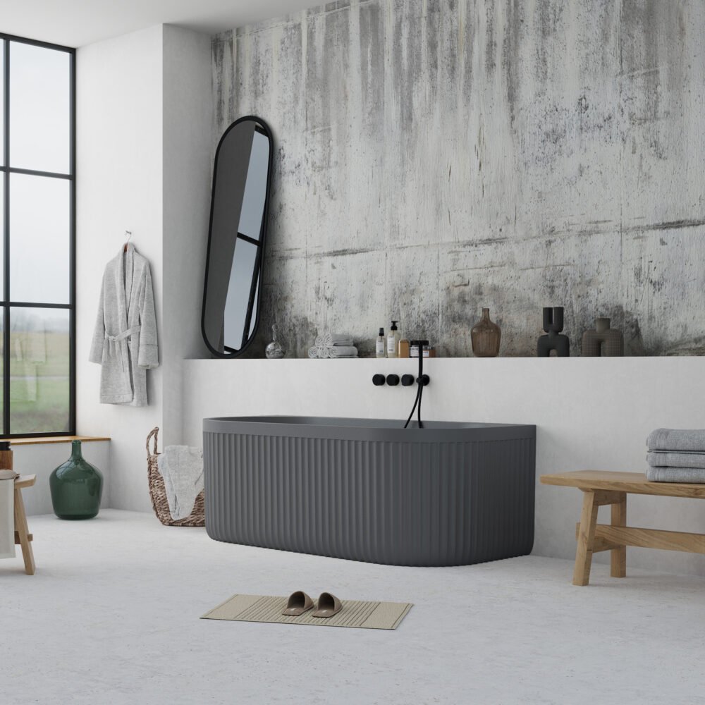 Modern bathroom setup featuring a grey back-to-wall bathtub with sculpted exterior and built-in overflow.
