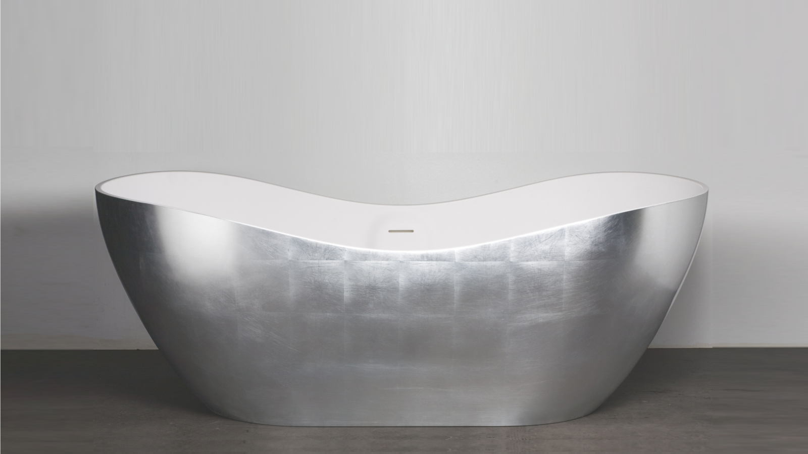 The Aquamar Silver Freestanding Bathtub by AquaDesign combines the elegance of a silver leaf exterior with the functionality of Cristalplant